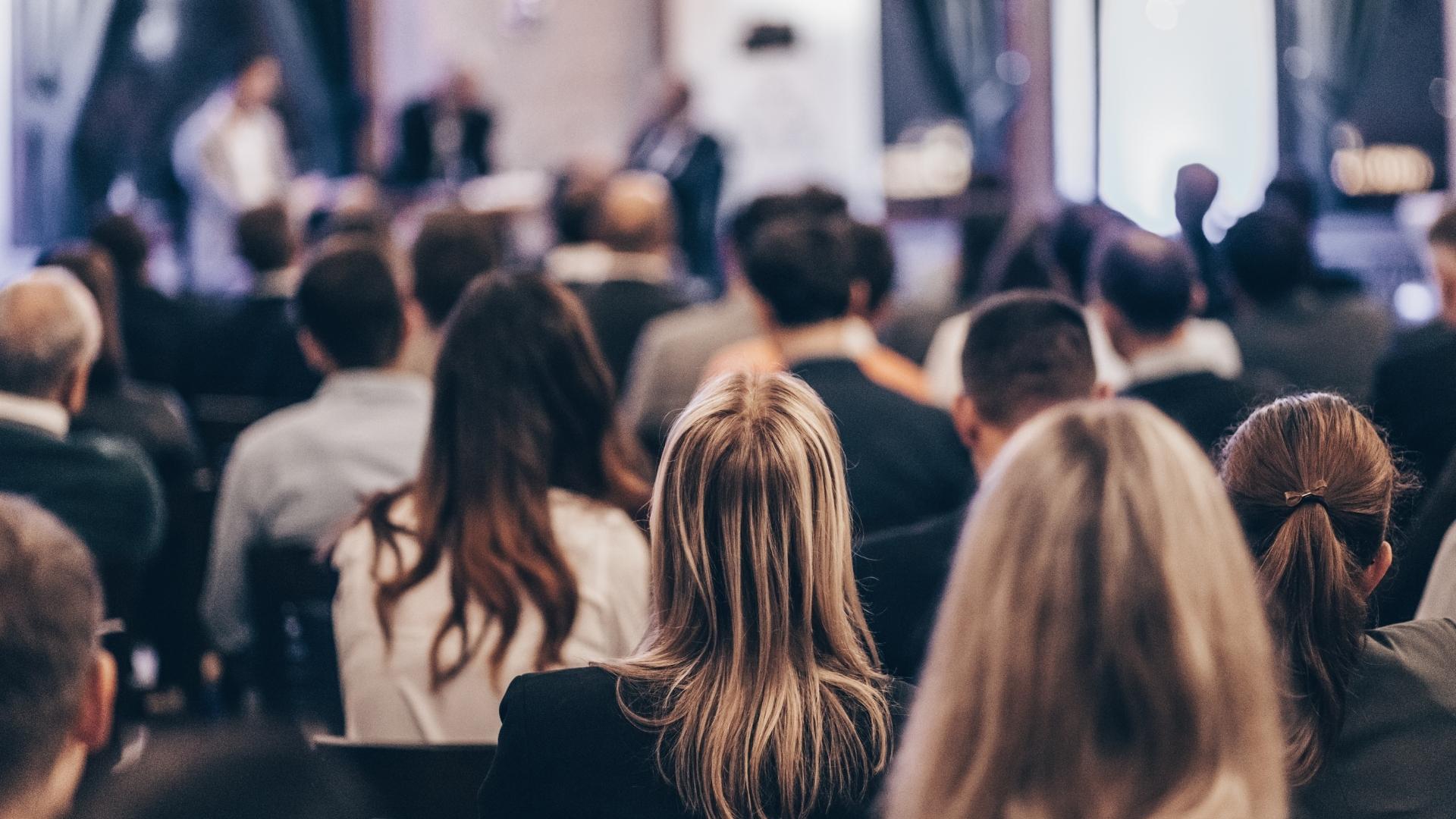 Publikum schaut aufmerksam einem Vortrag zu.