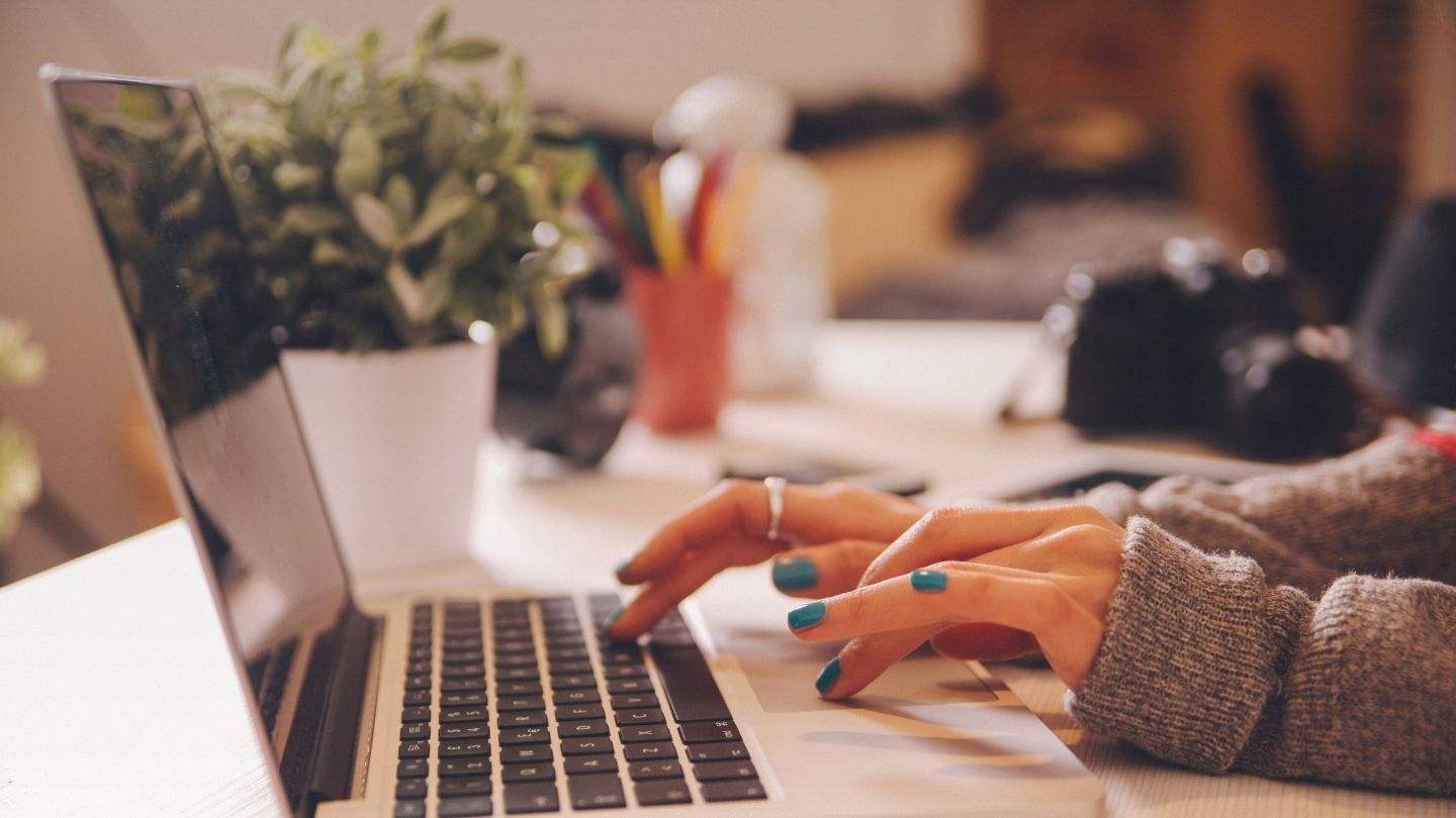 Frau tippt auf einer Laptop-Tastatur.