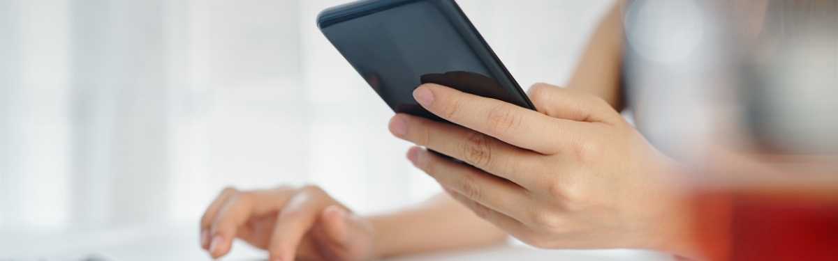 Frau nutzt Smartphone und Computer